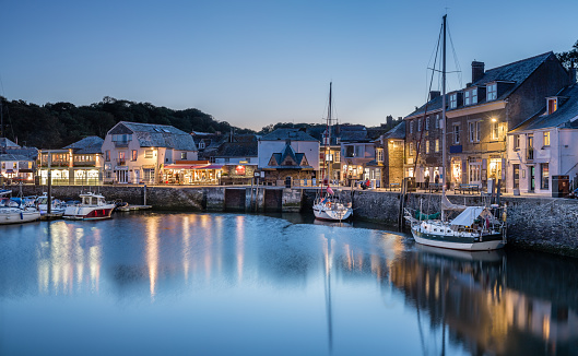 Padstow Harbour at blue hour, Cornwall, with reflections of the boats and lights in and around the harbour.
