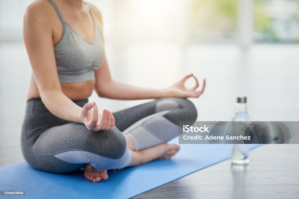 Meditating leads to an increase in self-awareness Closeup shot of an unrecognizable woman meditating in a studio Sports Bra Stock Photo