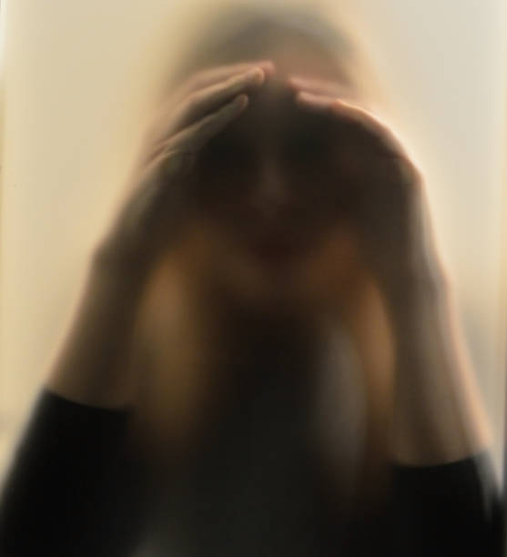 istock Girl looking behind frosted glass 1124699515