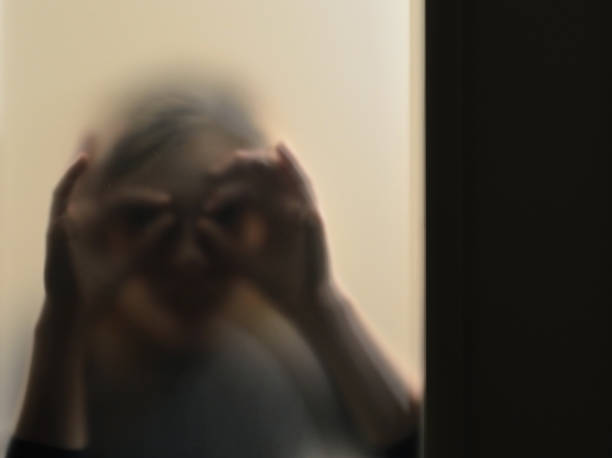 istock Girl looking behind frosted glass 1124699518