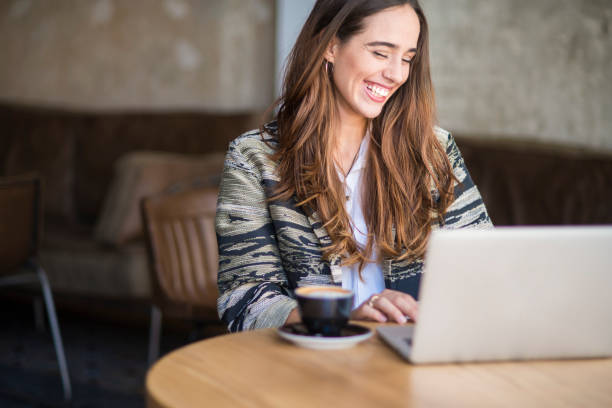 istock Smiling woman using laptop at the bar. 1124699576