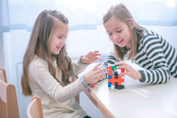 istock Schoolgirls on a Break Playing with Block Puzzle 1124700251
