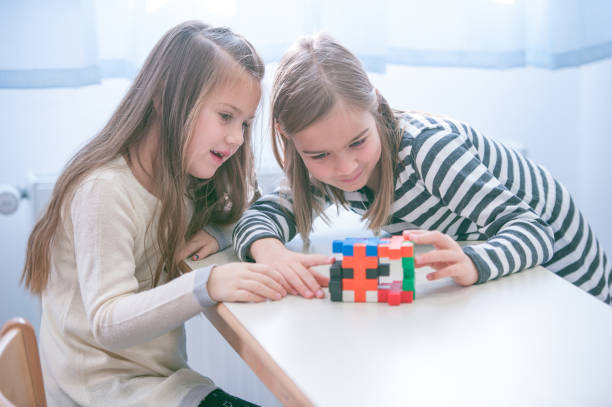 istock Schoolgirls on a Break Playing with Block Puzzle 1124700254
