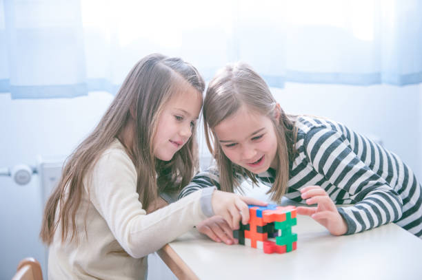 istock Schoolgirls on a Break Playing with Block Puzzle 1124700257