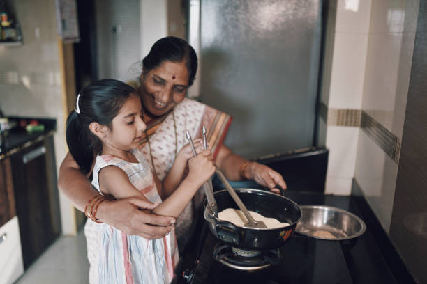istock Young girl helping her grandmother while working in the kitchen 1124704671