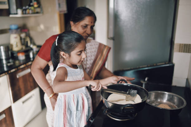 istock Young girl helping her grandmother while working in the kitchen 1124704785