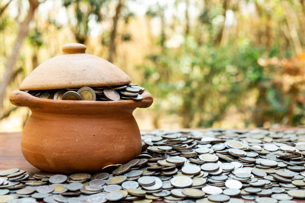 istock Coins in jar from on pile lots coin with blurred background, Money stack for business planning investment and saving concept 1124705416