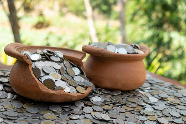 istock Coins in broken jar from on pile lots coin with blurred background, Money stack for business planning investment and saving concept 1124705617