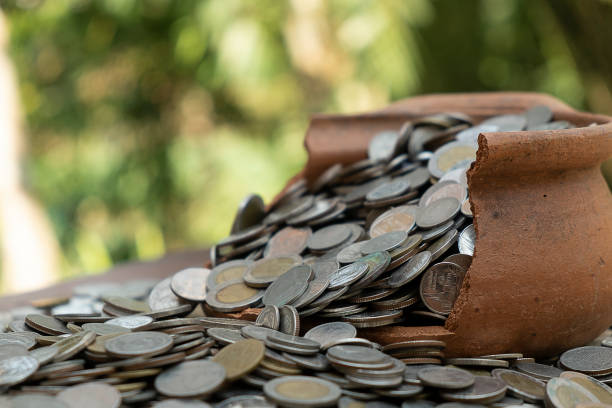 istock Coins in broken jar from on pile lots coin with blurred background, Money stack for business planning investment and saving concept 1124705979