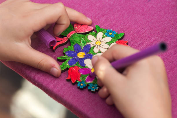 istock child paints with a felt-tip pen drawing on a wooden board close-up 1124707650
