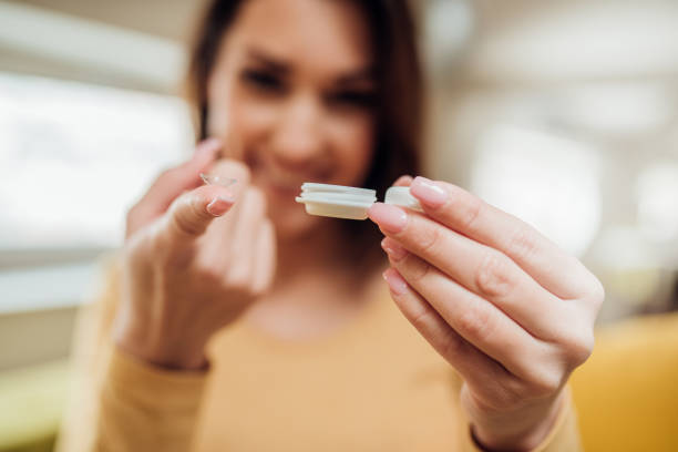 Woman holding contact lenses