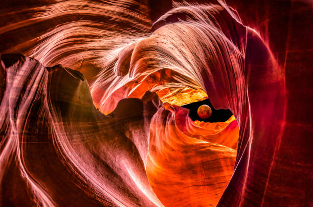 red supermoon eclipse in Upper Antelope Canyon Composite with Red full moon eclipse outside Upper Antelope Canyon upper antelope canyon stock pictures, royalty-free photos & images