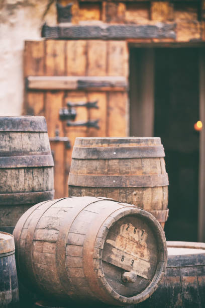 Antique oak barrels with steel hoops at the gates of the old house