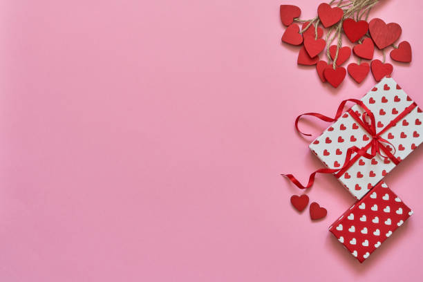 istock Valentines Day background. Red hearts and gift boxes on pink background. Copy space, top view 1124712914