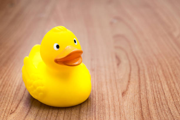 yellow rubber duck for bath on a wooden table - allegro imagens e fotografias de stock