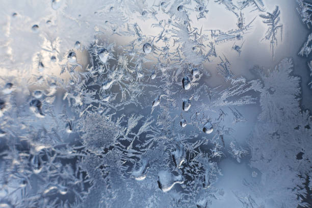Christmas frosty snowflake pattern on the window glass stock photo
