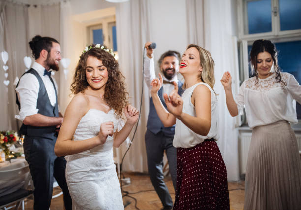 młoda panna młoda z innymi gośćmi tańczącymi na weselu. - party guest zdjęcia i obrazy z banku zdjęć