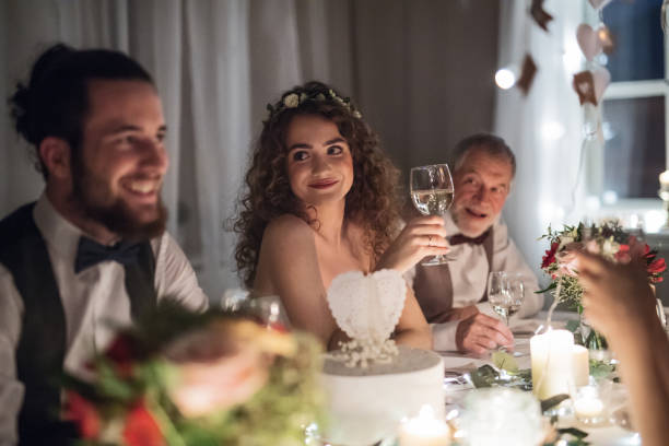 istock A young couple sitting at a table on a wedding, talking to guests. 1124714942