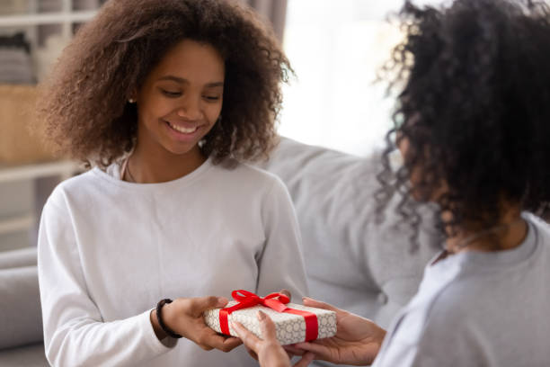 istock Black mom give birthday present to smiling daughter 1124715243