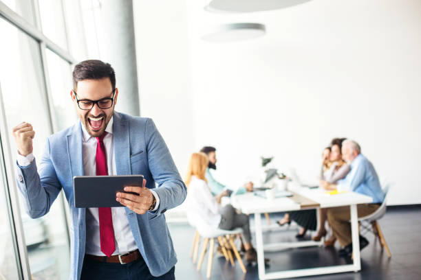 istock Young businessman reading good news on tablet 1124716828