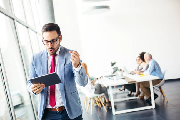 istock Young businessman reading good news on tablet 1124717069