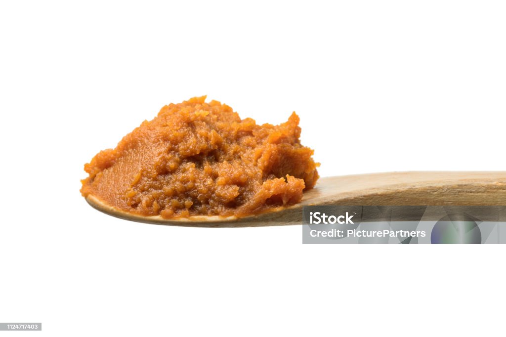 Wooden spoon with Japanese miso Wooden spoon with Japanese miso paste isolated on white background Miso Sauce Stock Photo