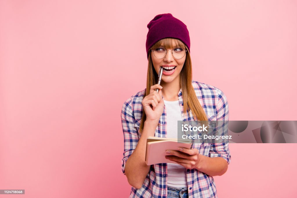 Portrait of nice winsome brainy genius attractive cheerful cunni Portrait of nice winsome brainy genius attractive cheerful cunning sly straight-haired girl wearing checked shirt holding in hands note-book isolated over pink pastel background Pen Stock Photo