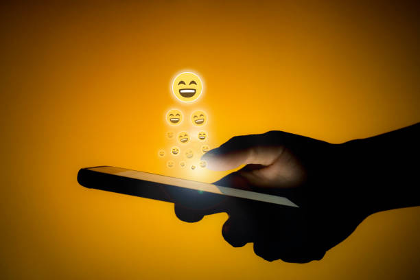 Human using phone sending smiley emojis stock photo