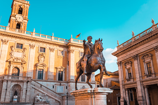 Bronze statue of Emperor Marcus Aurelius on horseback in the center of Piazza del Campidoglio in Rome with the town hall