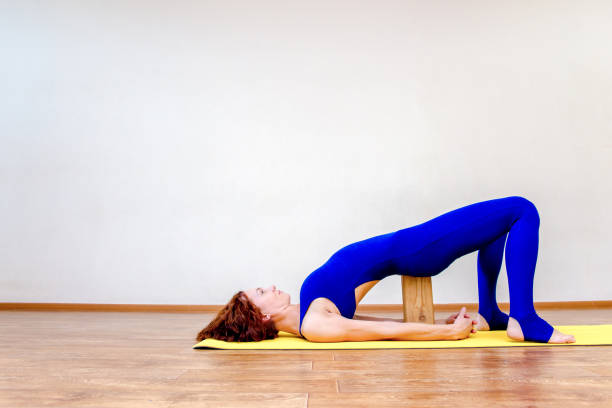 istock a woman practicing yoga exercises at home 1124725967