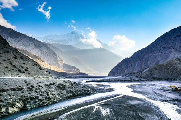 Colorful landscape with high Himalayan mountains, beautiful curving river, green forest, blue sky with clouds and yellow sunlight at sunset in autumn in Nepal. Mountain valley. Travel in Himalayas