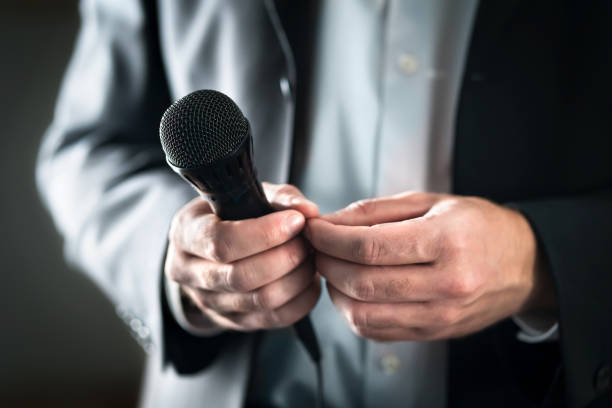 concept de trac. nerveux et timide orateur public avec microphone. homme d’affaires peur de donner la parole pour la foule de personnes ou d’audience. mains moites tenant mic. mauvaise présentation. - expressive hands audio photos et images de collection