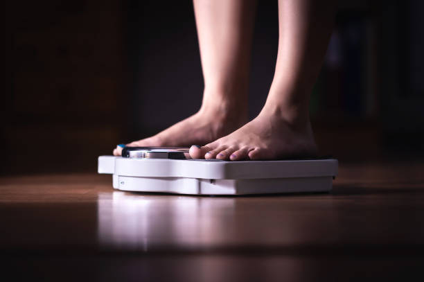 piedi in scala. perdita di peso e concetto di dieta. donna che si pesa. fitness signora dieta. perdita di peso e dietetica. - emaciated weight scale dieting overweight foto e immagini stock