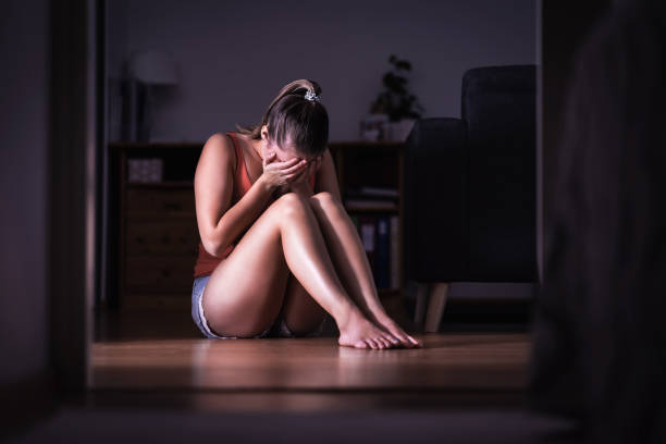 victim of sexual harassment, domestic violence or abuse. young sad woman crying and sitting on the floor at home. ashamed, scared or lonely lady suffering emotional pain. - domestic issues imagens e fotografias de stock