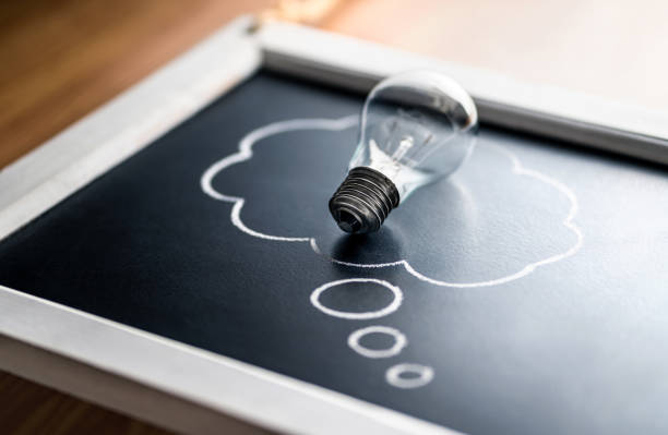 Intellectual property, new idea, psychology or brainstorm concept. Creativity, innovation and inspiration. Energy consumption. Light bulb on blackboard.