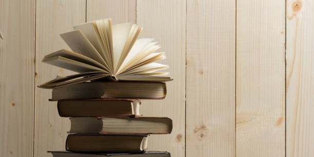 istock Open book, hardback books on wooden table. Back to school. Copy space 1124733646