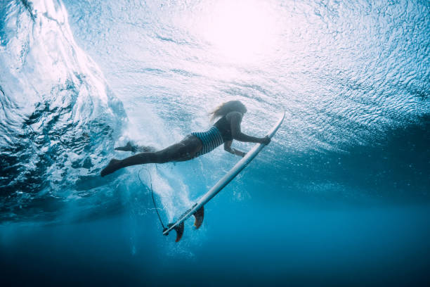 istock Surfer woman dive underwater with under wave. 1124734313