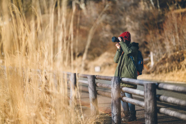 istock Young woman taking photos in nature 1124735979