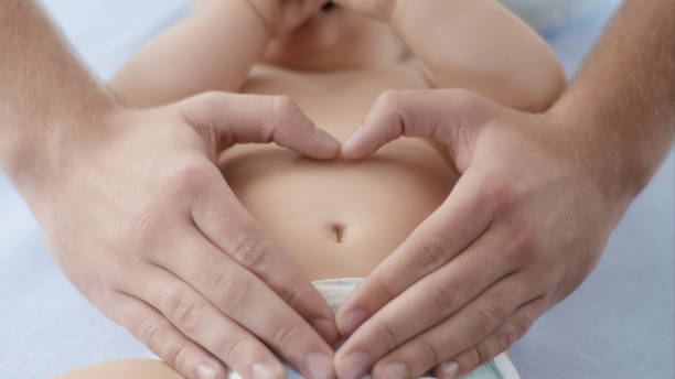 Well fed baby is a happy baby Holding hands on baby belly navel stock pictures, royalty-free photos & images