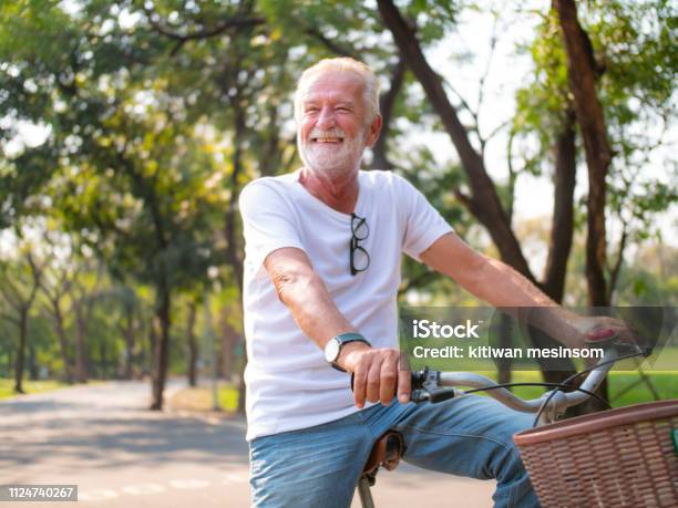 Portrait Senior Man On Cycle Ride In The Park Stock Photo - Download Image Now - Senior Men, Bicycle, Exercising
