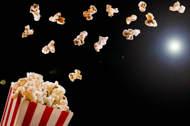 istock Popcorn flying out of cardboard box. Isolated on black background 1124742547