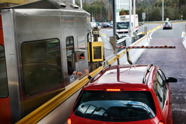 stuurprogramma in rode auto betalen bij tol gate op snelweg - brennerpas stockfoto's en -beelden