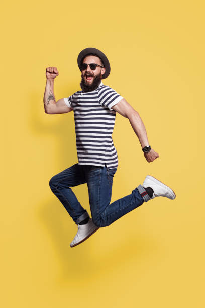 istock hipster man in hat and sunglasses jumping 1124742842