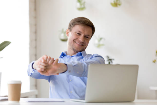 istock Smiling businessman stretching after finished work at workplace 1124743046