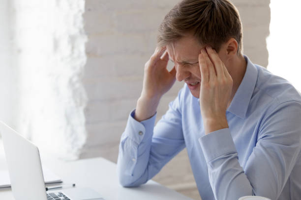 istock Frustrated businessman feeling pain, massaging temples at workplace 1124743106