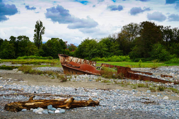 Rusty ship stranded aground on the beach with pebbles in the Black Sea.
