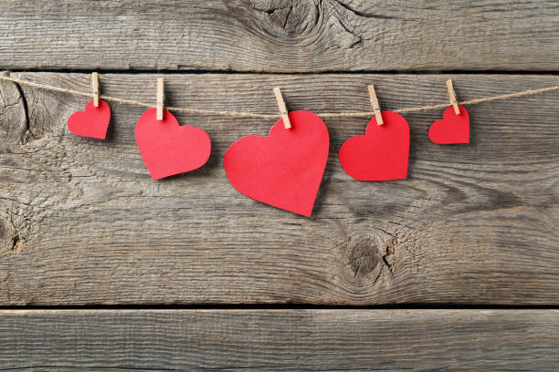 istock Red paper hearts hanging on wooden background 1124746218