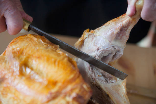 istock Man cuts roast turkey leg closeup 1124746893
