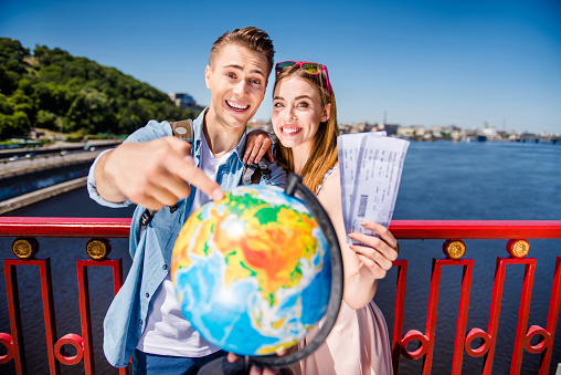 Journey dream day time summertime two people concept. Close up photo of cheerful ecstatic cute nice glad funky positive style stylish teen couple hold hot agency ticket travel o river sea ocean pier