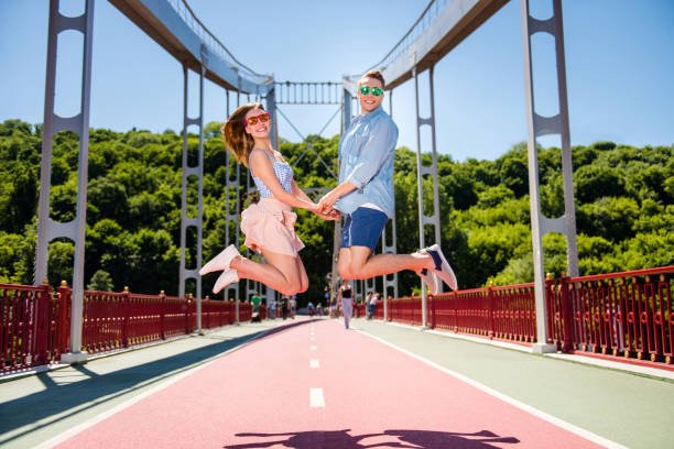 Outside carefree careless emotion expression concept. Full length size body photo of excited crazy funny funky delightful spouses traveling jumping up